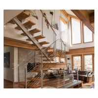 Escalier sur mesure à poutre monobloc en acier, marches en noyer massif, système de garde-corps en verre, éclairage LED intégré aux marches