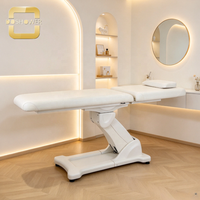Table de massage électrique blanche avec rembourrage épais en PU, moteur silencieux et base stable pour les cliniques de médecine esthétique et les instituts de beauté
