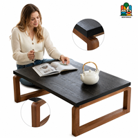 Table basse minimaliste en bois massif avec plateau noir anthracite et pieds à structure ouverte, style rustique moderne