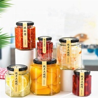 Toples kaca bentuk segi enam kustom kualitas tinggi untuk penyimpanan makanan selai madu dengan tutup
