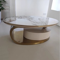 Table basse ovale moderne avec dessus en pierre frittée, pieds en métal beige, imbriqués et extensibles, pour salons confortables