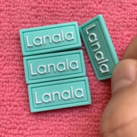 Étiquettes en caoutchouc de relief de petit logo, label en caoutchouc de PVC de logo simple avec la Manche de couture