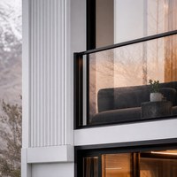 Maison en conteneurs d'acier à deux étages avec terrasse sur le toit, grandes baies vitrées et escalier extérieur