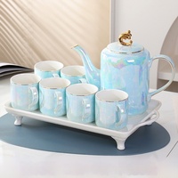 Elegante tetera de cerámica y 6 tazas de té con un mango de color dorado y una tapa con un acabado brillante iridiscente