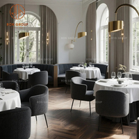 Ensemble de meubles Ron Group : banquettes de restaurant modernes en velours bleu, tables rondes en marbre blanc et chaises à pieds en métal noir