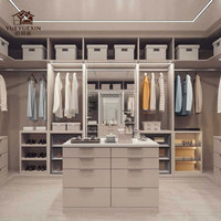 Grande dressing moderne ouverte avec finition en bois naturel et tiroirs à fermeture amortie