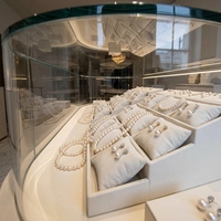 Moderner Cremeweißer Ovaler Schmuck-Präsentationstisch LED-Beleuchtete Glasvitrine für Einzelhandels-Schmuckgeschäfte