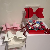 Boîte d'emballage en papier avec grand nœud rouge, blanc, rose et bleu, avec couvercle transparent