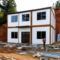 Maison conteneur démontable à ossature blanche, deux étages, toit à pignon, balcon, porte vitrée pour habitation familiale en banlieue