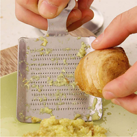 Éplucheur et presse-ail en forme de spatule pour gingembre et ail