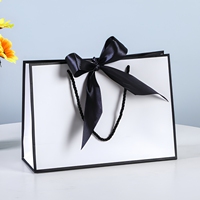 Sacs cadeaux en carton recyclable de luxe avec nœud, poignées longues, impression de logo personnalisée pour l'emballage de vêtements, de cosmétiques et d'artisanat