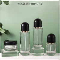 Ensemble de flacons cosmétiques et de pots à crème en verre transparent de luxe avec des bouchons en dôme noir et une pompe dorée pour l'emballage des soins de la peau