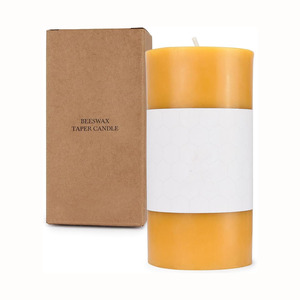Beeswax pillar candle with art deco banding and warm honey-colored glow