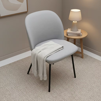 Fauteuil lounge contemporain avec dossier rembourré doux, assise large et base à quatre pieds noire pour réception d'hôtel