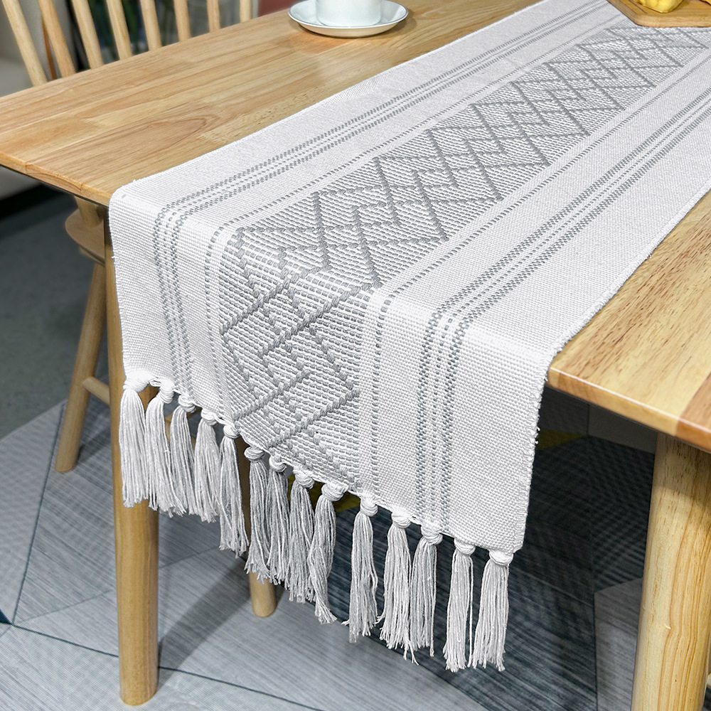 Runner da tavola bianco e grigio con nappine a forma di diamante incrociato
