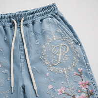 Ensemble survêtement streetwear personnalisé : sweat à capuche oversize zippé et pantalon de survêtement coupe droite, en denim déchiré, avec impression DTG et broderie de patchs