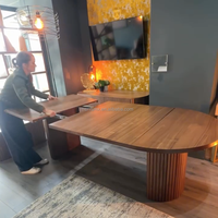 Table transformable ovale fabriquée en bois massif de qualité supérieure, s'étend sans effort pour accueillir jusqu'à 12 invités avec bancs et buffet.