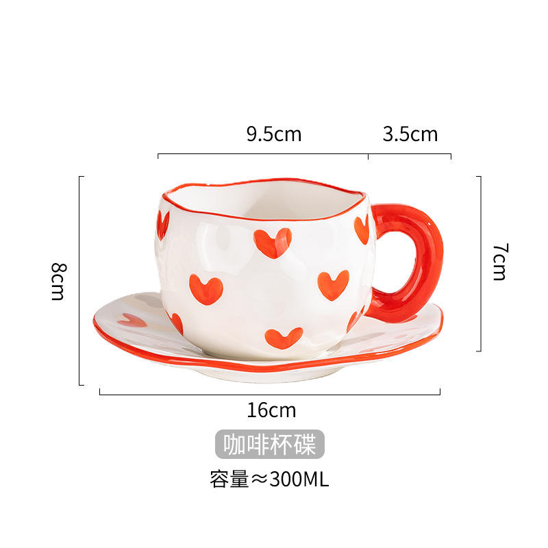 Taza de café y plato moldeados a mano con forma de corazón rojo.