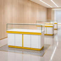 Vitrine d'exposition de style chinois en panneaux stratifiés blancs avec bordure dorée, éclairage LED et îlot en verre pour boutique de détail et exposition de parfums