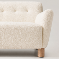 Canapé 2 places en bouclette crème, dossier capitonné boutonné, accoudoirs arrondis, pieds cylindriques en bois, causeuse moderne et minimaliste pour salon