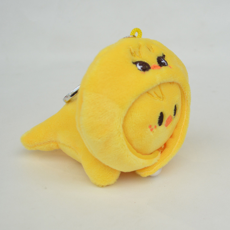 Porte-clés poulet jaune en pose inclinée avec chapeau.