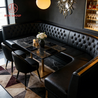 Canapé de restaurant moderne de luxe en cuir noir avec base en métal doré et table en marbre, mobilier de restaurant écologique et durable