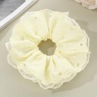 Bandeau pour cheveux avec dentelle ajourée en forme de cœur et cordon à franges pour une coiffure chignon douce et charmante.