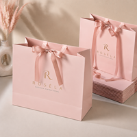 Sac de courses élégant et professionnel en papier blanc avec nœud, imprimé en héliogravure personnalisé pour les marques de vêtements de créateurs et les cadeaux de mariage