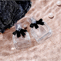 Vente en gros de flacons carrés en verre transparent de 50 ml avec finition mate, nœud noir, couvercle en acrylique anti-fuite, pompe pulvérisatrice pour parfum