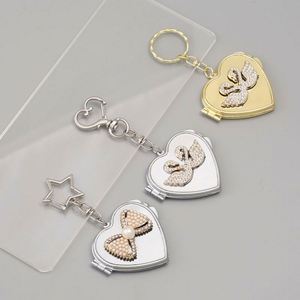 Al por mayor: Llavero de aleación plateada ligero estilo vintage coreano para espejo, con colgante de lazo de perlas Y2K, para accesorios de bolsos de nicho - Product Image 1