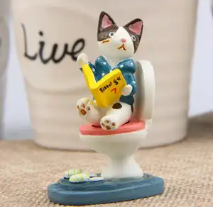 गर्म पदोन्नति के साथ एक बिल्ली शौचालय पर बैठता एक पुस्तक के लिए राल आंकड़े कार्टून शिल्प गुड़िया मिनी परी उद्यान सजावट है।