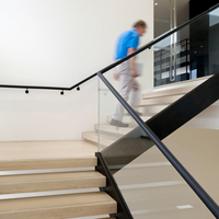 Escalier droit moderne et contemporain pour intérieur, à double poutre, structure acier-bois, garde-corps en verre, marches en pierre
