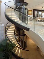 Escalier en spirale en marbre courbé Tanlong, garde-corps en verre courbé noir, éclairage LED pour villa penthouse en Australie
