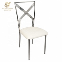 Chaise de mariage moderne en acier inoxydable argenté avec dossier croisé et coussin en velours blanc, idéale pour la location d'événements et banquets, vente en gros