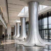 Colonne décorative haute en aluminium sur mesure, base à pétales évasés, finition brossée sablée, joint vertical pour l'aménagement d'atriums d'hôtels