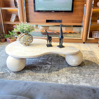 Table basse Kumusi en travertin avec plateau en forme de poire et pied sphérique