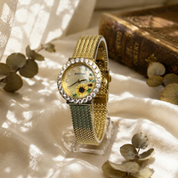 Montre élégante en or rose avec cadran rose, motif fleur de cerisier, index des heures sertis de diamants et bracelet en acier inoxydable maillé, mouvement à quartz