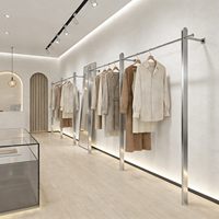 Présentoir mural de luxe léger en acier inoxydable brossé pour vêtements et robes de mariée, idéal pour les magasins de prêt-à-porter féminin