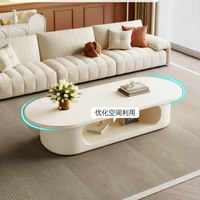 Table basse ovale blanc crème, base de rangement ouverte creuse, style minimaliste, profil bas, pour salon, table à thé