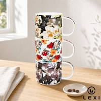 Ensemble de trois tasses en céramique à motifs floraux contrastés, fond noir, fleurs encadrées, hibiscus blanc, motif botanique aquarelle