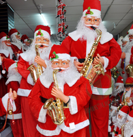 Père Noël électrique en gros, jouant du saxophone, en mouvement et chantant
