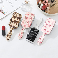 Brosse à cheveux démêlante portable style Coquette avec motif nœud léopard et coussin d'air, peigne de massage à palettes pour femmes