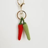 Le petit pendentif en forme de piment tissé à la main de Bubagxiangyu et l'exquis porte-clés en laine Zhi Nu en forme de petit piment.