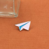 Broche en émail élégante et simple avec un design d'avion en papier, adaptée aux personnes soucieuses de la mode dans une esthétique minimaliste.