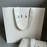 Sacs en papier texturé de luxe avec logo personnalisé et poignée en ruban pour le shopping, l'emballage et les expositions