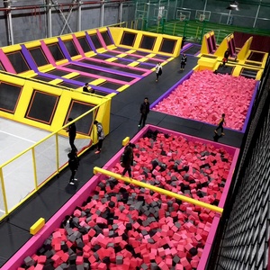 <span class=keywords><strong>Parc</strong></span> de trampolines intérieur sur mesure, conçu et aménagé, avec une grande zone de jeux souple, incluant des blocs en mousse, des plateformes et une filet de protection. - Product Image 1