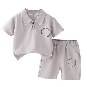 नई शैली के ग्रीष्मकालीन लड़कों के लिए ठोस रंग लेटर-लैपल छोटी आस्तीन वाला टॉप और मैचिंग शॉर्ट्स सूट