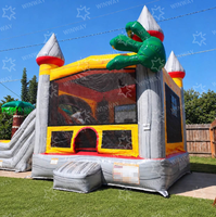 Château gonflable géant sur le thème des dinosaures volcaniques, aire de jeux gonflable avec palmiers et toboggan pour carnaval de jardin
