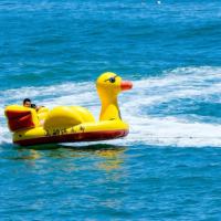 Bateau gonflable géant en forme de canard jaune pour 3 à 5 personnes, idéal pour les activités aquatiques estivales, pour enfants et adultes.