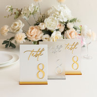 Numéros de table de mariage en acrylique blancs avec numéros sérigraphiés or et supports de présentation